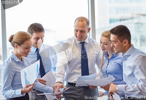 Image of business people with papers talking in office