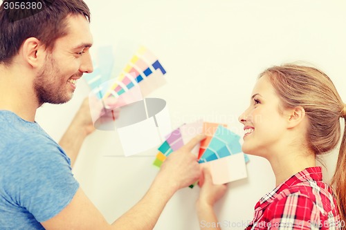 Image of smiling couple looking at color samples at home