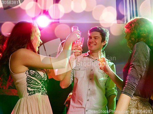 Image of smiling friends with glasses of champagne in club