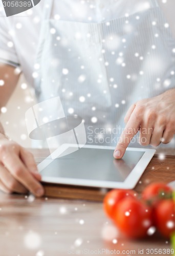 Image of closeup of man reading recipe from tablet pc