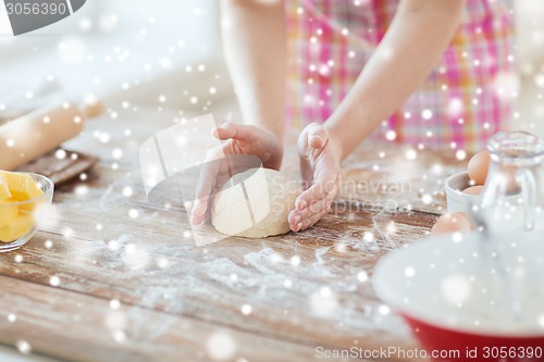 Image of close up of female hands kneading dough at home