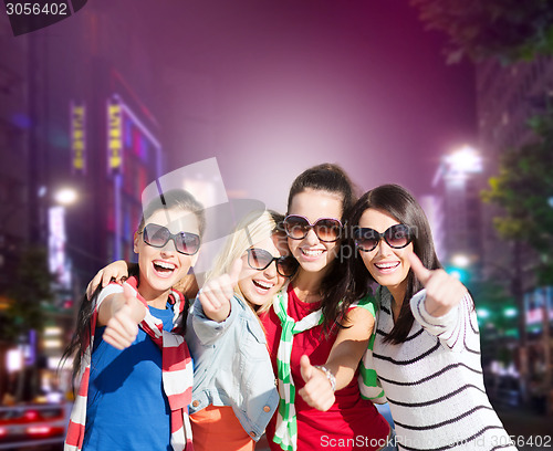 Image of group of young women showing thumbs up in city