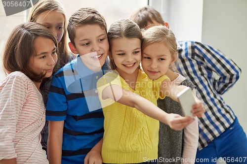 Image of group of school kids taking selfie with smartphone