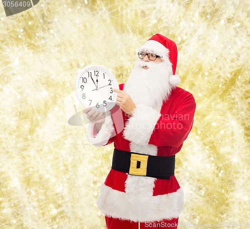 Image of man in costume of santa claus with clock