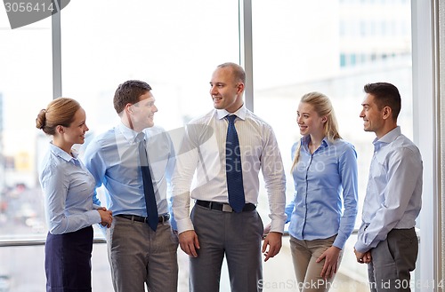 Image of smiling business people talking in office