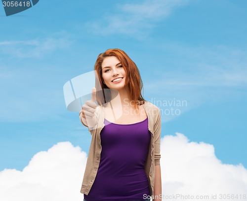 Image of smiling teenage girl showing thumbs up
