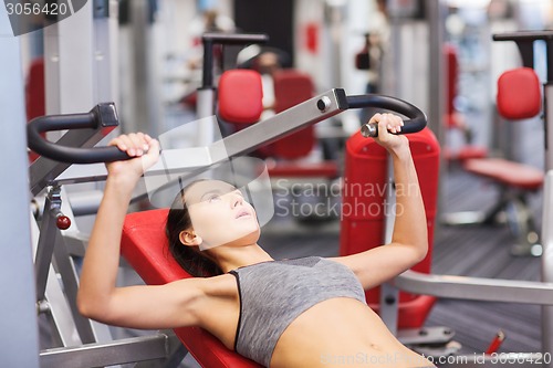 Image of young woman exercising on gym machine