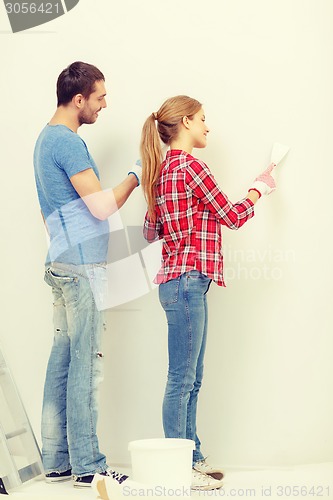 Image of smiling couple doing renovations at home