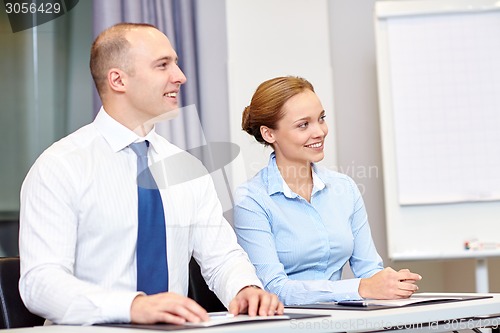 Image of group of smiling businesspeople meeting in office