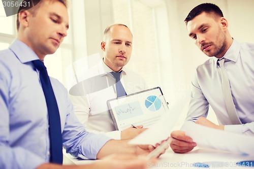 Image of serious businessmen with papers in office