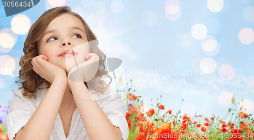 Image of happy girl dreaming over poppy field background