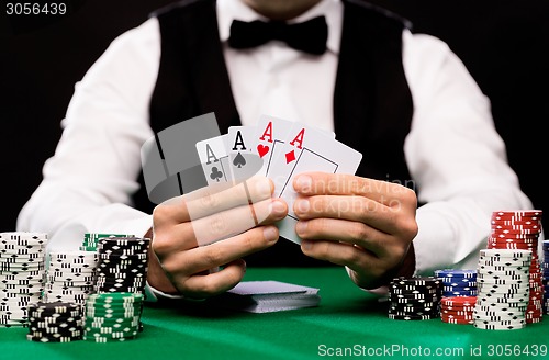 Image of poker player with cards and chips at casino