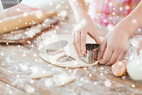 Image of close up of woman hands making cookies from dough