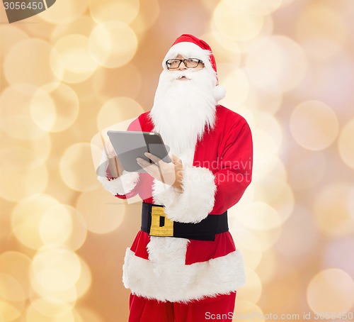 Image of man in costume of santa claus with tablet pc