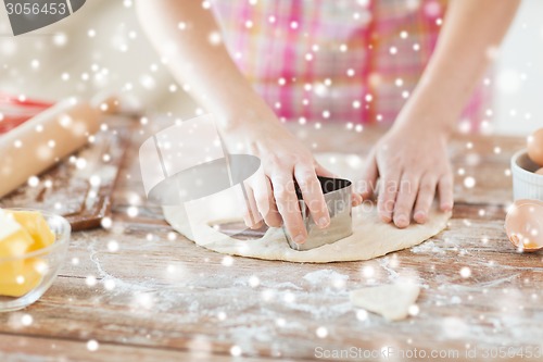 Image of close up of hands making cookies from fresh dough