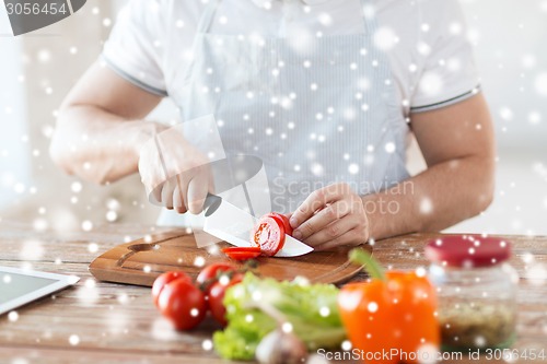 Image of close up of man cutting vegetables with knife