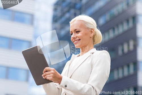 Image of smiling businesswoman with tablet pc outdoors