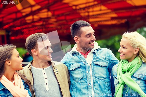 Image of group of smiling friends in amusement park