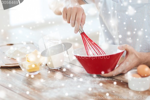 Image of close up of man whipping something in bowl