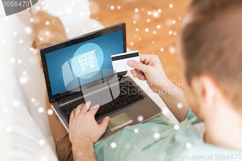 Image of close up of man with laptop and credit card