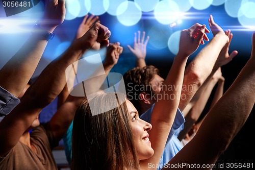 Image of smiling friends at concert in club