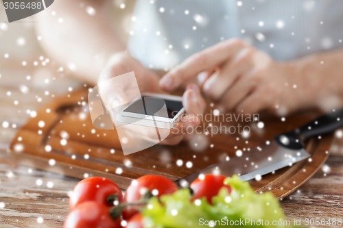 Image of closeup of man reading recipe from smartphone