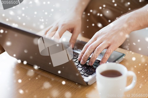 Image of close up of man with laptop and coffee cup at home