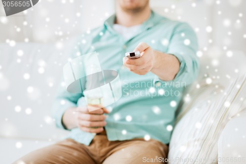 Image of man with beer and remote control at home