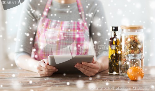 Image of close up of woman reading recipe from tablet pc