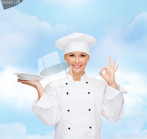 Image of female chef with empty plate showing ok sign