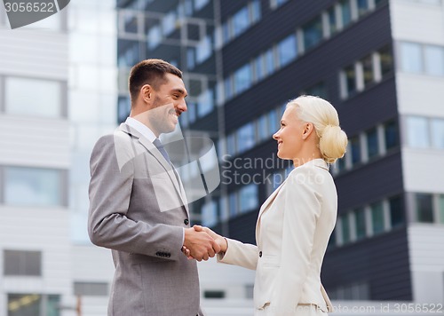 Image of smiling businessmen standing over office building