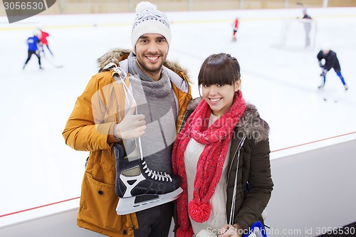 Image of happy couple with ice-skates on skating rink