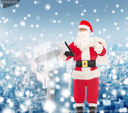 Image of man in costume of santa claus with notepad and bag