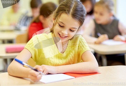 Image of group of school kids writing test in classroom