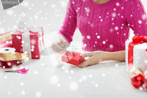 Image of close up of woman decorating christmas presents