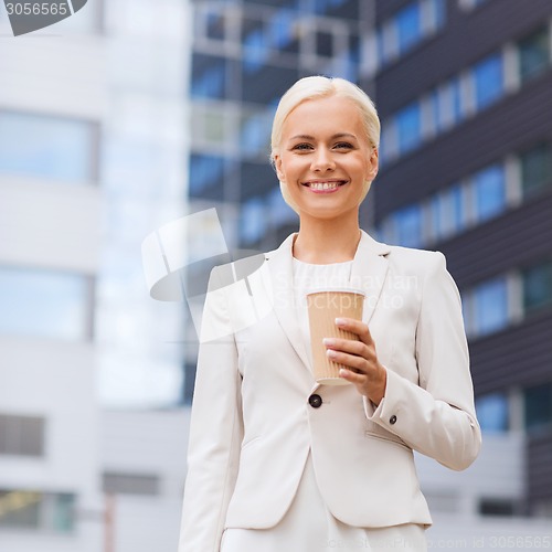 Image of smiling businesswoman with paper cup outdoors