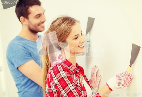 Image of smiling couple doing renovations at home