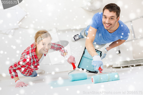 Image of smiling couple with roll and tray painting wall