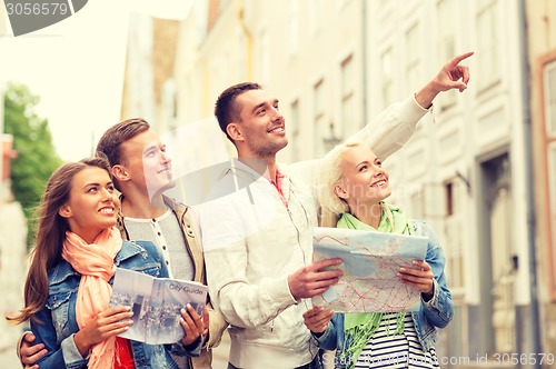 Image of group of smiling friends with city guide and map