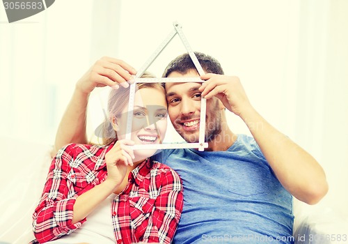 Image of smiling couple with house from measuring tape