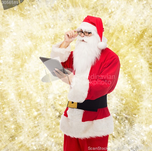 Image of man in costume of santa claus with tablet pc