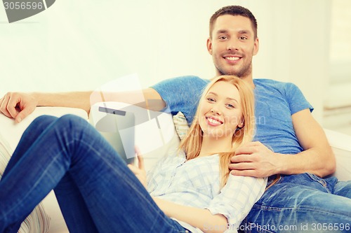 Image of smiling happy couple with tablet pc at home
