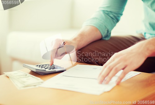 Image of close up of man counting money and making notes