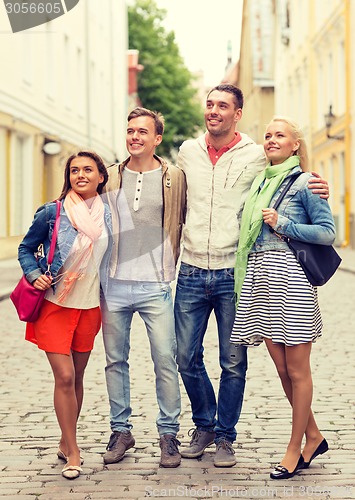 Image of group of smiling friends walking in the city