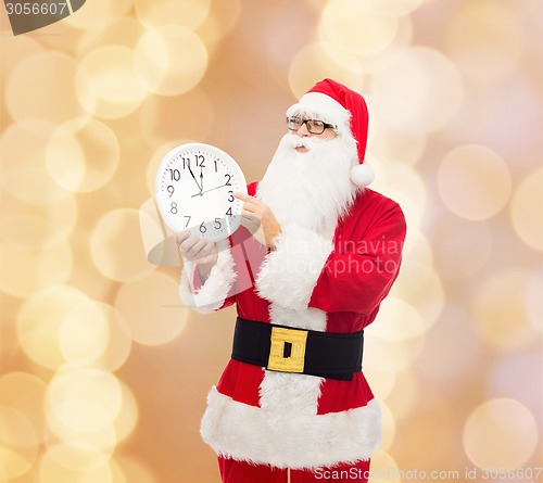 Image of man in costume of santa claus with clock