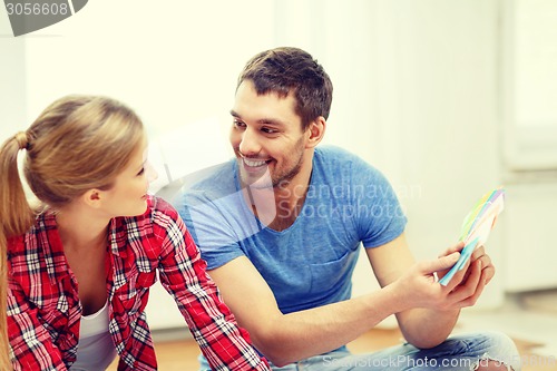 Image of smiling couple looking at color samples at home