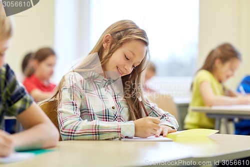 Image of group of school kids writing test in classroom