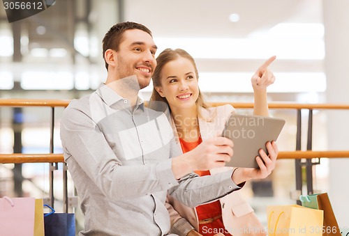 Image of couple with tablet pc and shopping bags in mall