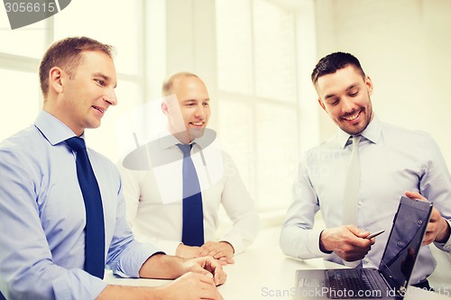 Image of smiling businessmen having discussion in office