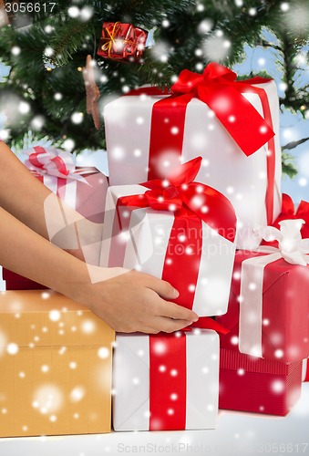 Image of close up of woman with gifts and christmas tree